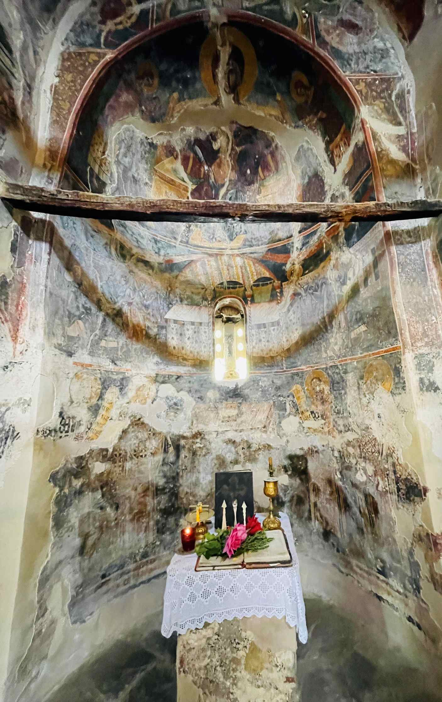 Al fresco paintings in church with small altar and wooden beam in Berat Albania